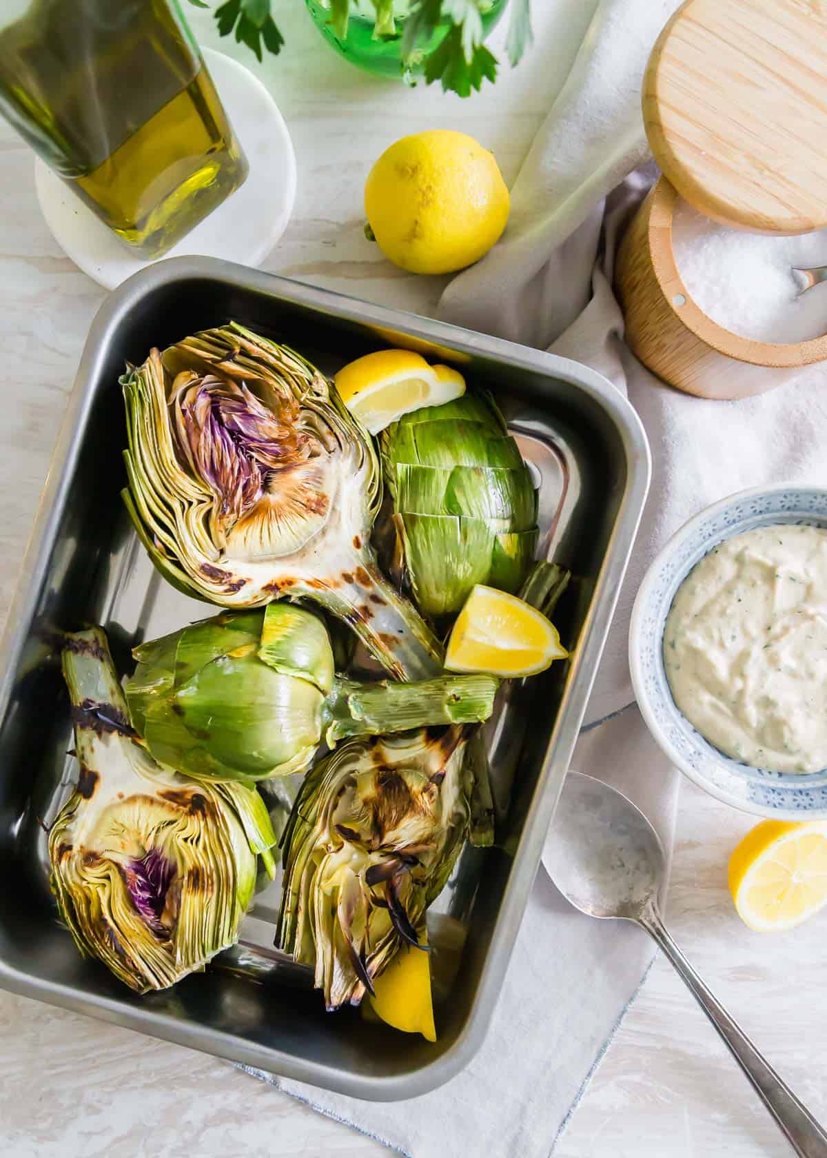 Simple grilled artichokes are a great new way to enjoy this lovely spring vegetable with a tasty tahini lemon dipping sauce.