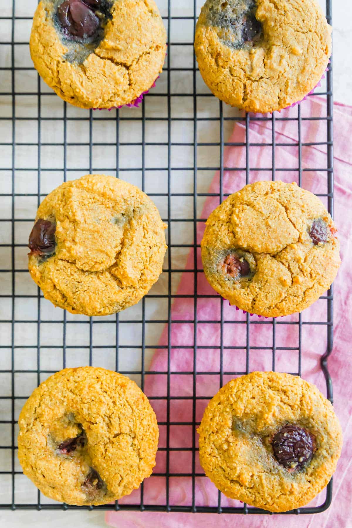 Vegan cornmeal muffins made with cornmeal and almond flour have a hearty texture and slightly sweet flavor filled with fresh summer cherries.