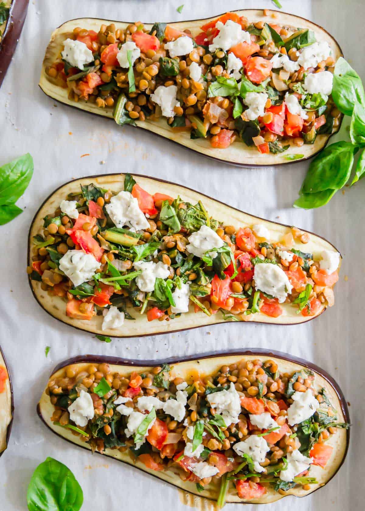 Lentil stuffed eggplant is a hearty meatless meal filled with brown lentils, tomatoes, onions and greens. Top with goat cheese for a creamy bite or leave off for a vegan version.