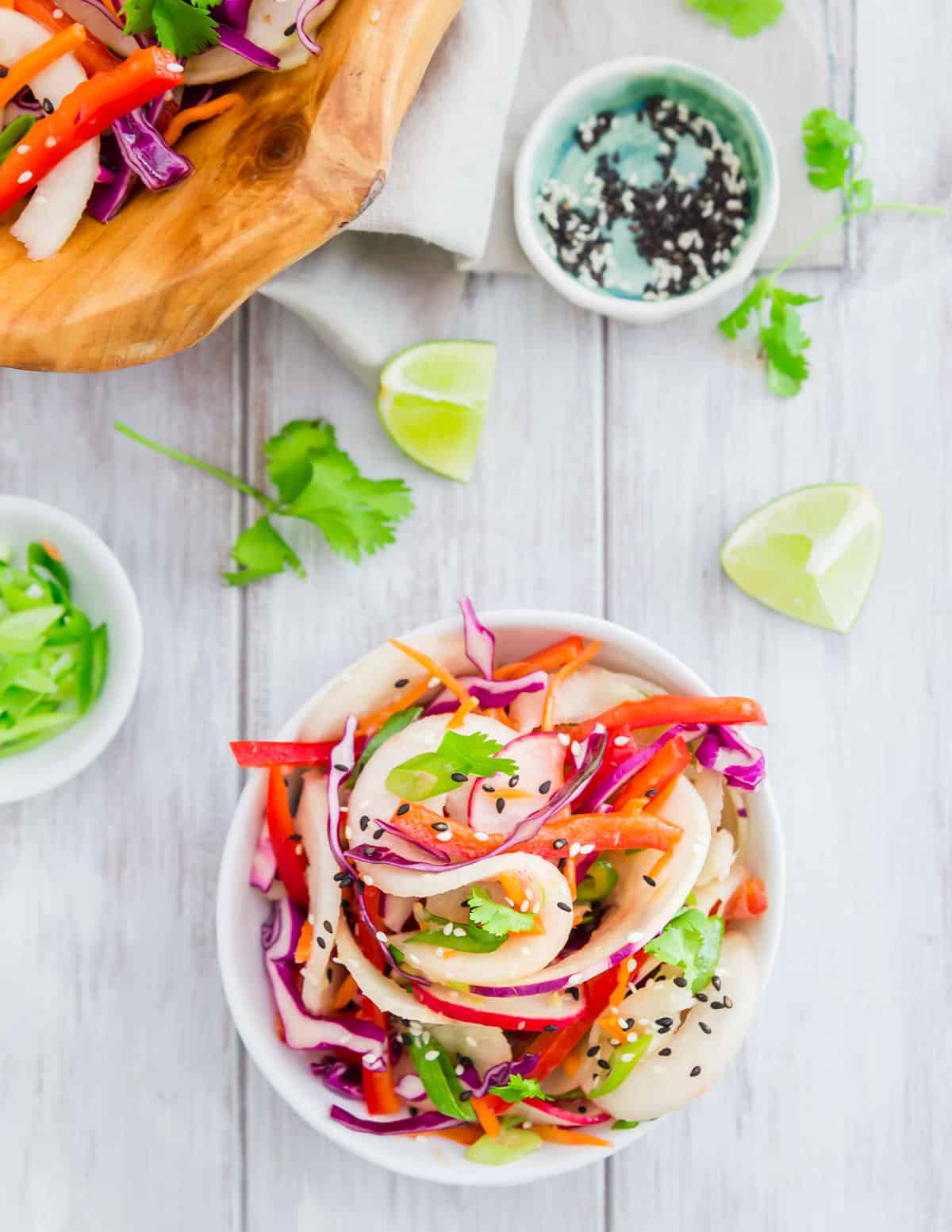 Spiralized kohlrabi noodles make the base of this healthy Thai inspired salad with cabbage, red peppers, carrots, radish, jalapeño and green onion in a simple Asian flavored vinaigrette.