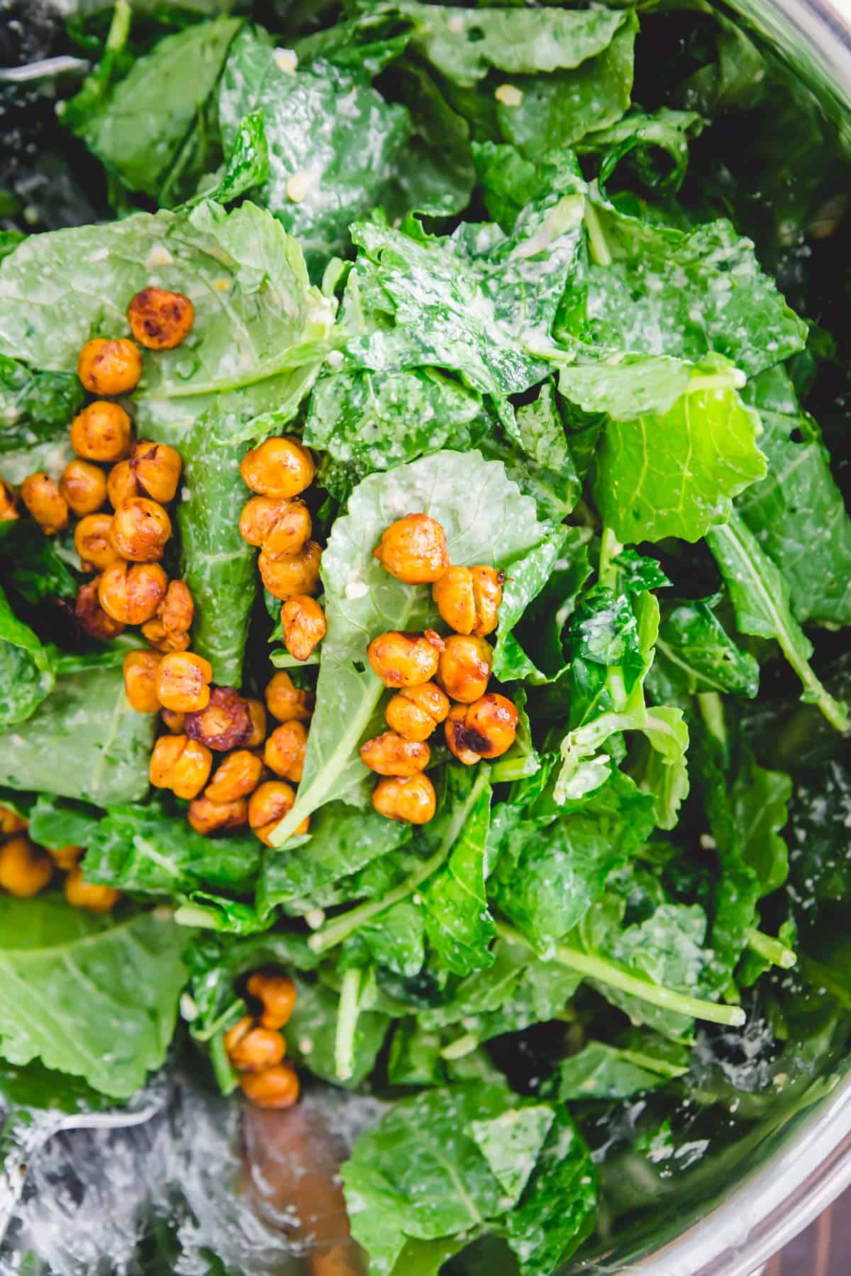 Los garbanzos asados se añaden a esta ensalada de col rizada baby para obtener un poco de proteína saludable llena de fibra.