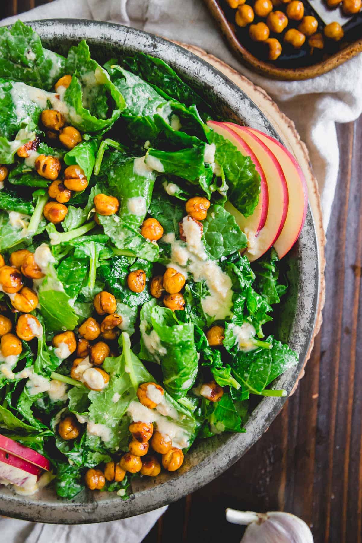 Thinly sliced apples, roasted chickpeas and a creamy tahini dressing make this the best baby kale salad recipe.