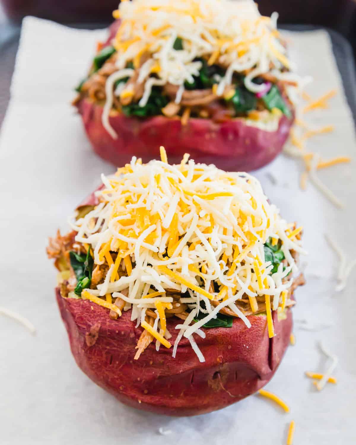 brisket stuffed potatoes before baking topped with lots of shredded cheddar cheese