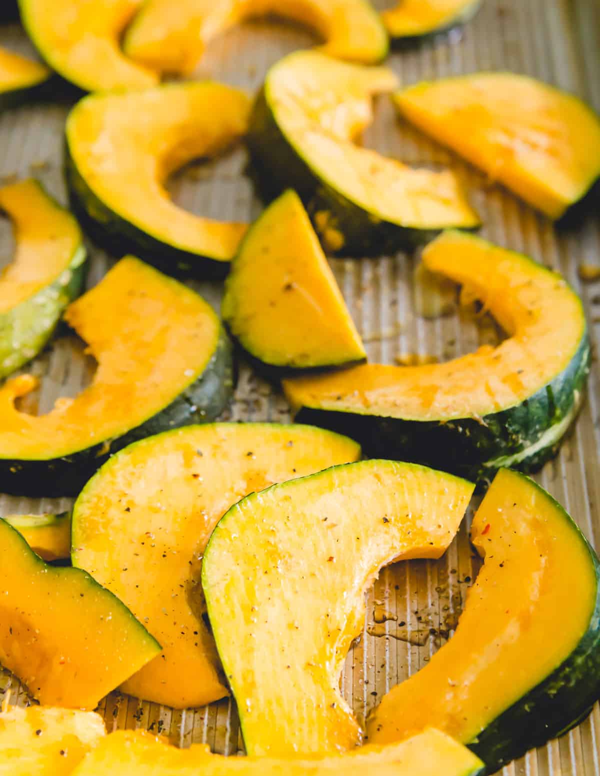 Sliced buttercup squash on a baking sheet before roasting in the oven.