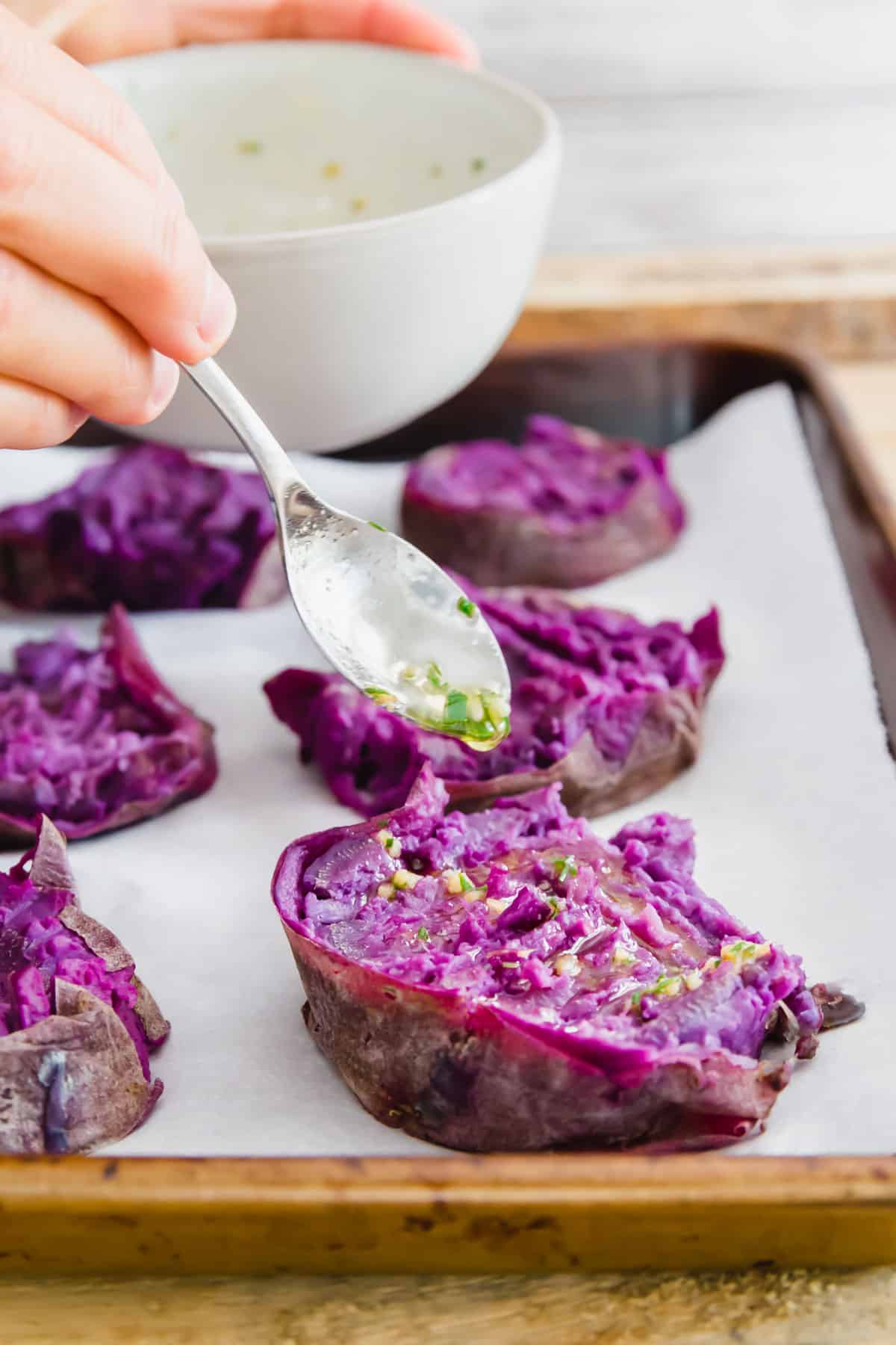 This easy purple sweet potato recipe smashed, drizzled with ghee and herbs and broiled until crispy is the perfect side dish to any meal.