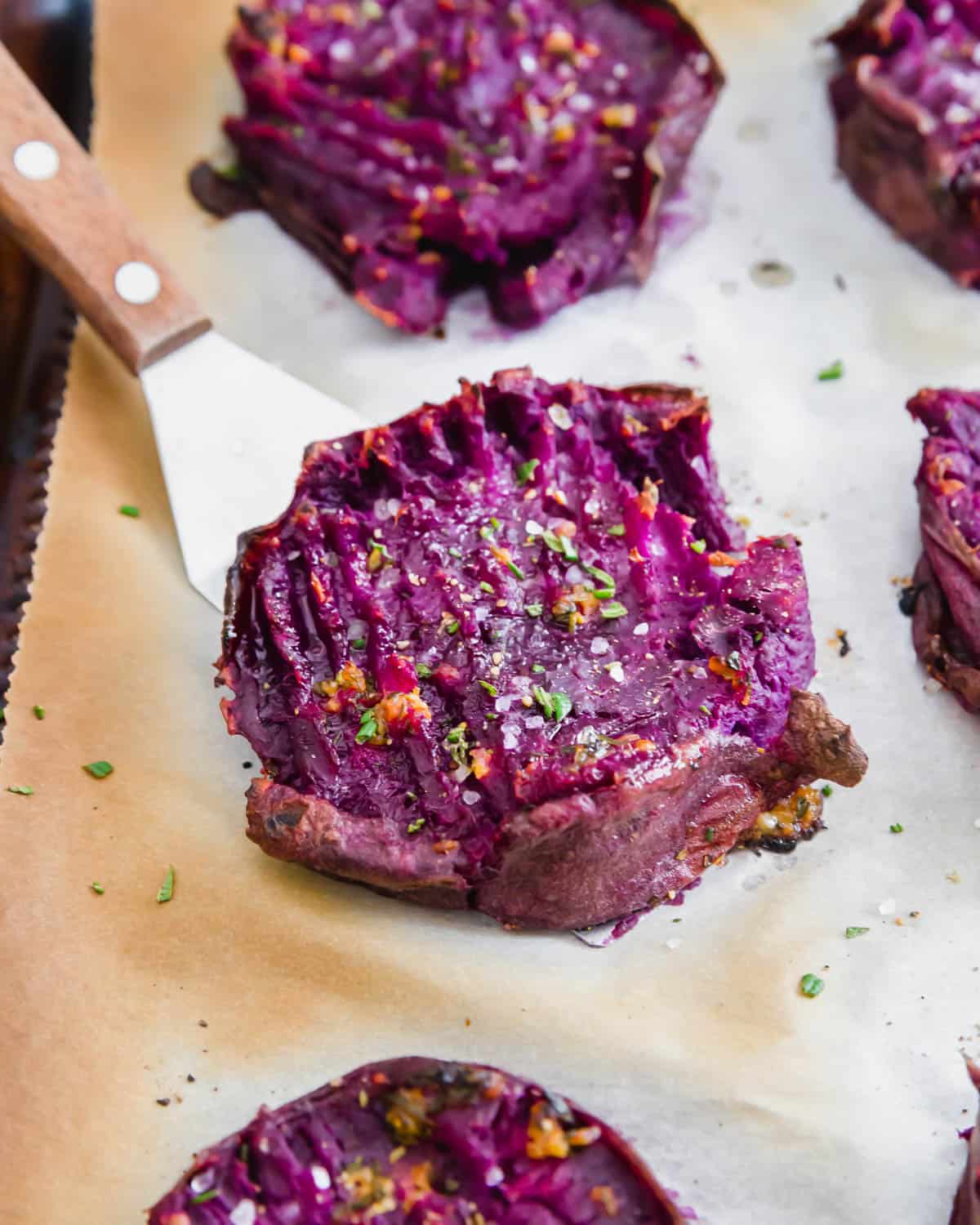 Crispy roasted purple sweet potatoes with melted butter and herbs.