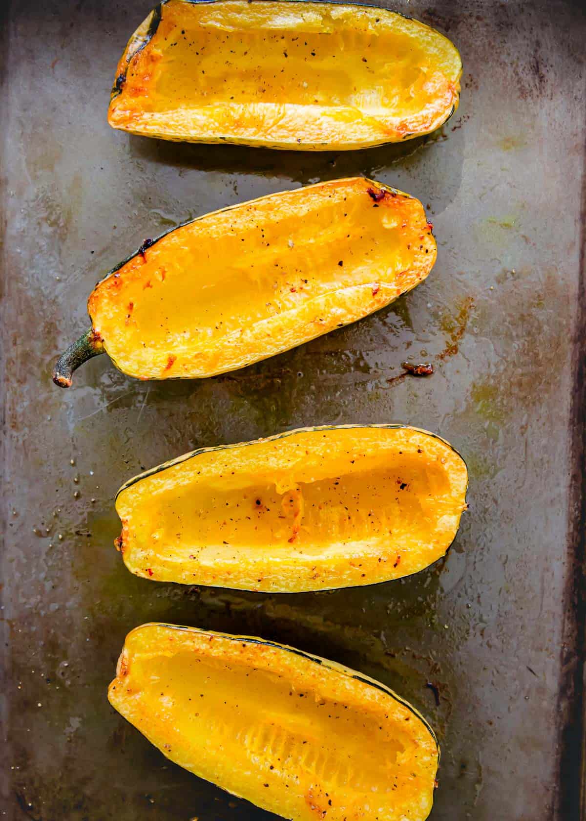 Oven roasted delicata squash cut in halves before stuffing.