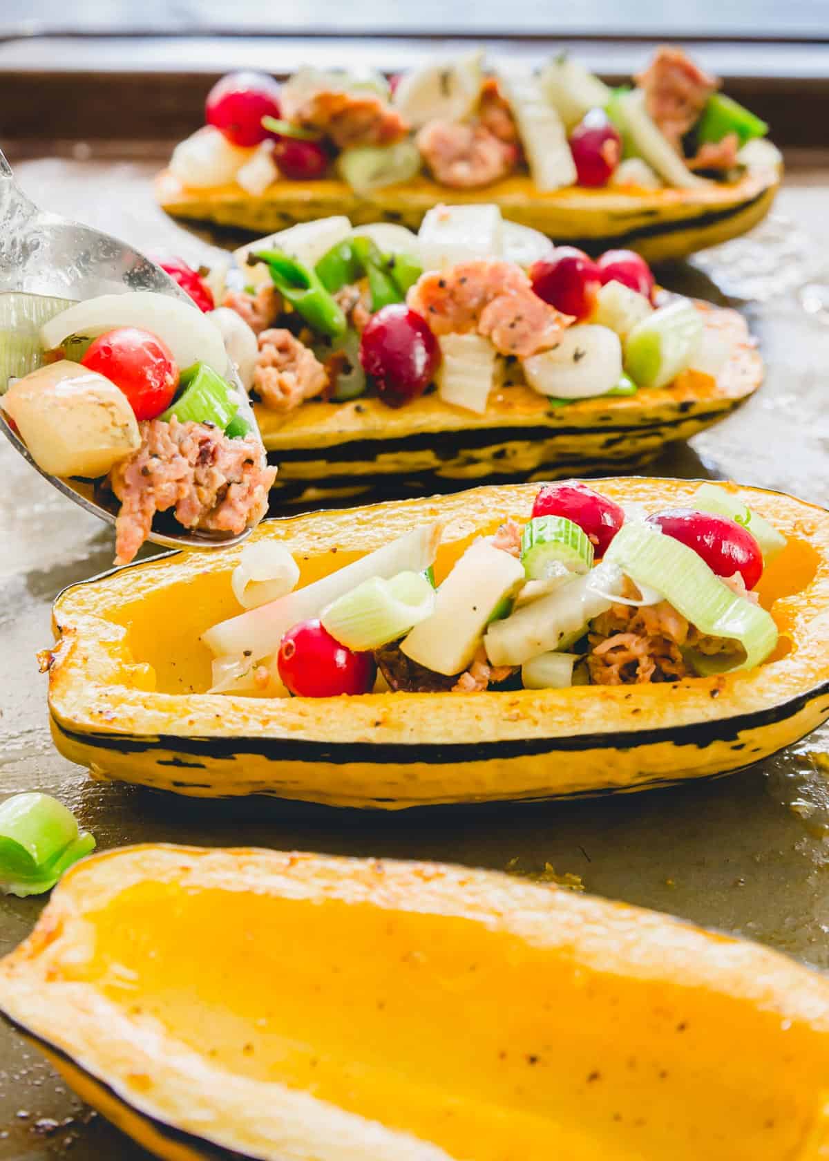 Stuffing the roasted delicata squash "boats" with the ground pork filling.