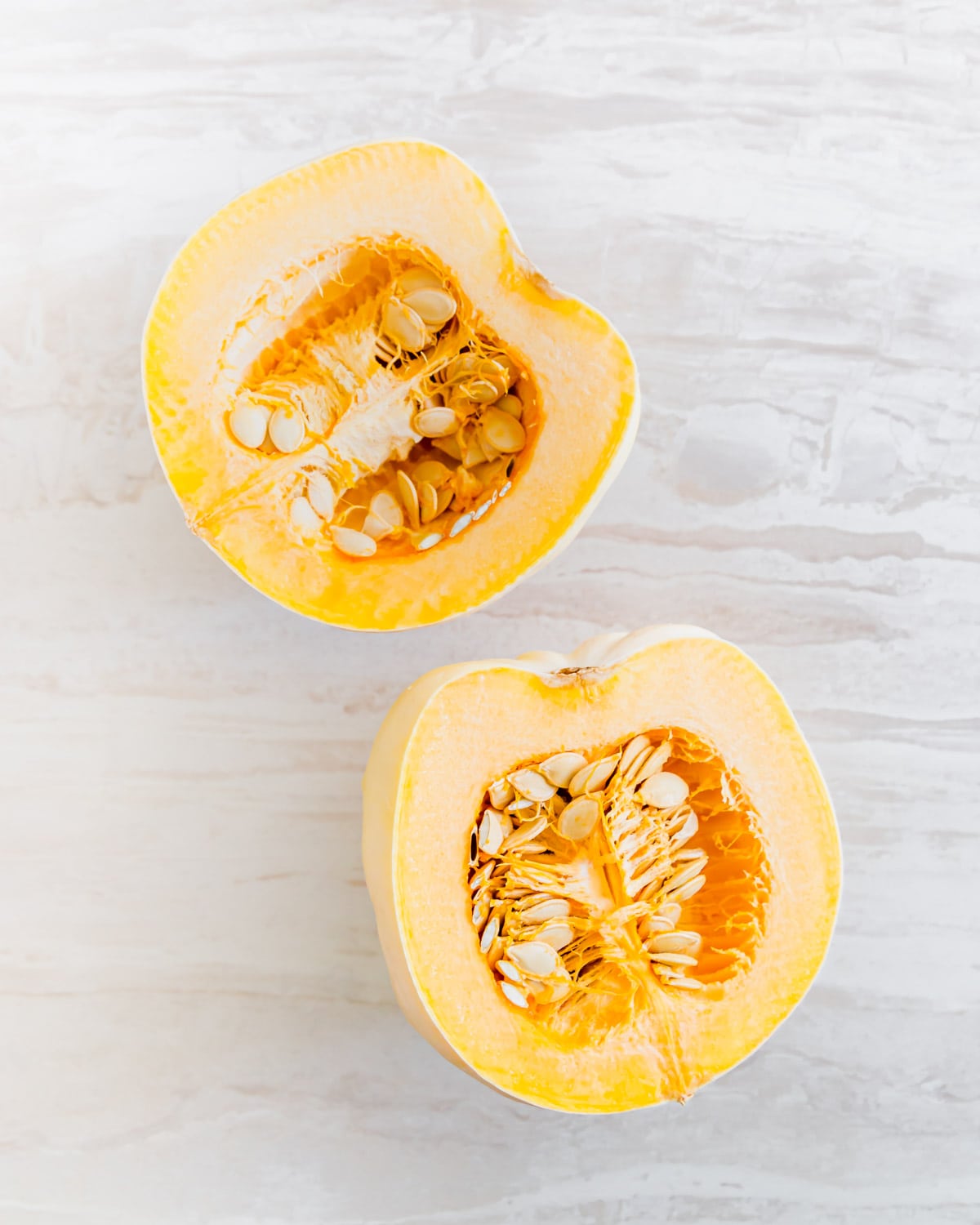 halved white acorn squash with seeds