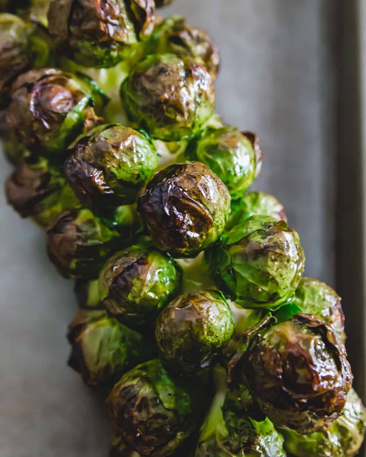 Whole roasted Brussels sprouts on the stalk with an easy maple balsamic glaze.