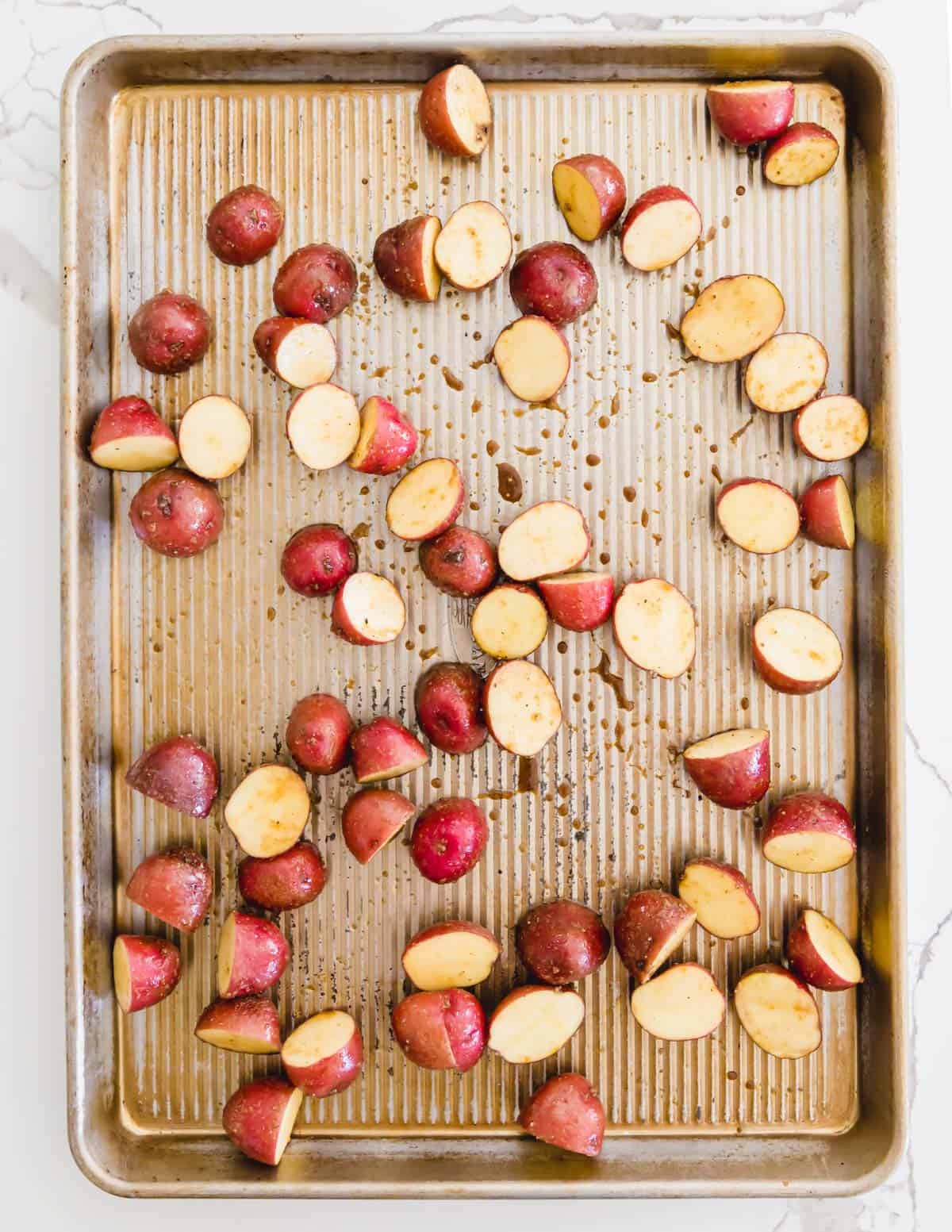 baby red potatoes on a sheet pan to roast with asparagus