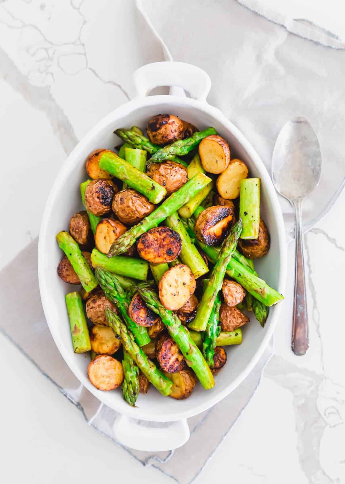 This easy side dish of oven roasted potatoes and asparagus is made all on one baking sheet with garlic balsamic seasoning.