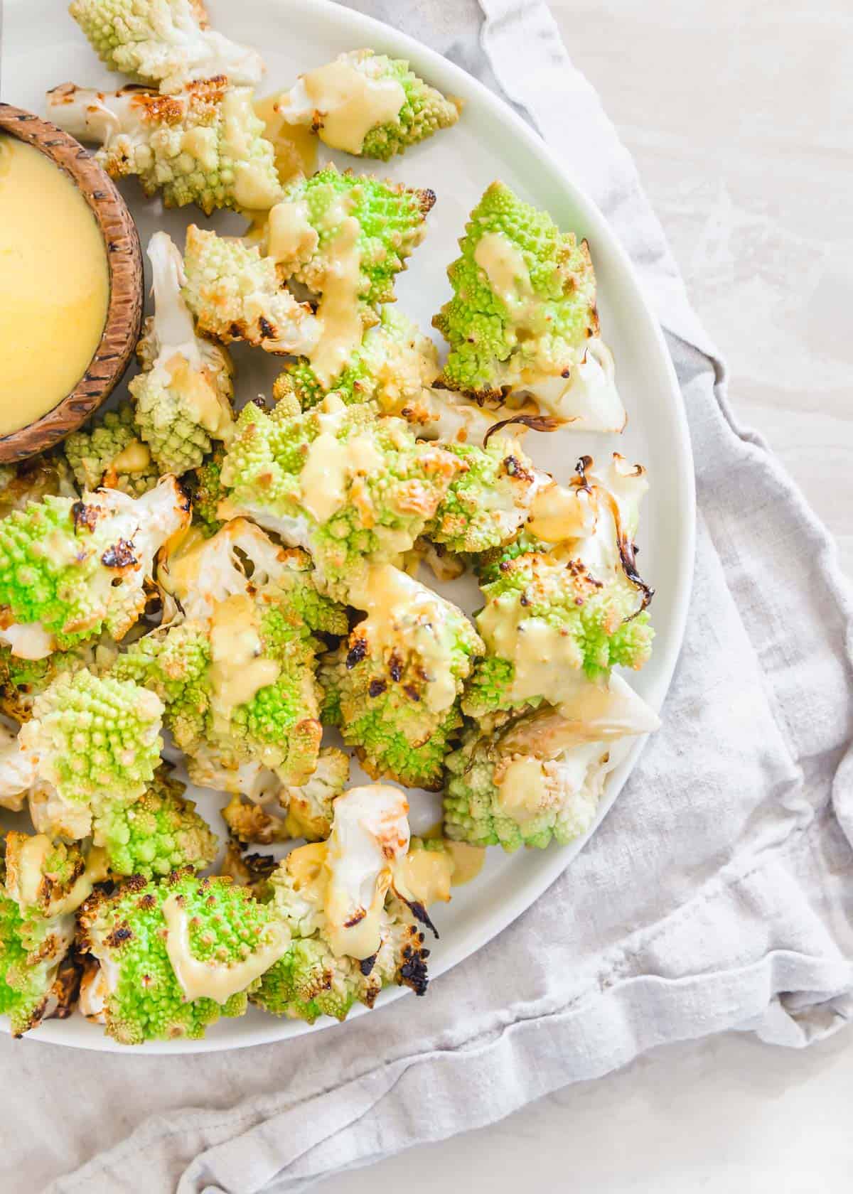 Roasted romanesco is a simple way to enjoy this spiky cruciferous vegetable that's a fun cross between cauliflower and broccoli. A simple creamy turmeric tahini sauce is perfect to serve alongside! Roasted romanesco is a simple way to enjoy this spiky cruciferous vegetable that's a fun cross between cauliflower and broccoli. A simple creamy turmeric tahini sauce is perfect to serve alongside!