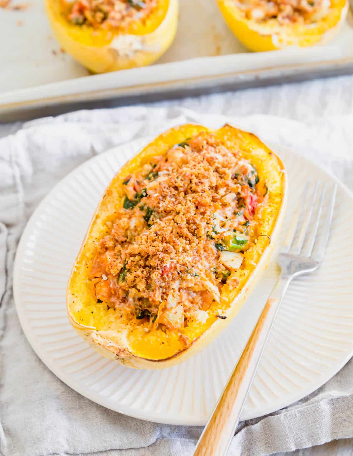 Delicious twice baked spaghetti squash is filled with spinach, artichokes, tomatoes and cheese.