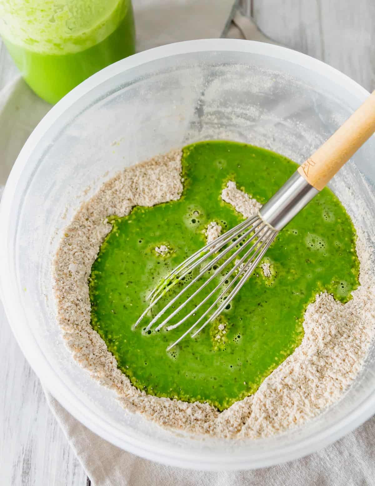 Mixing wet and dry ingredients to make green spinach pancakes for St. Patrick's Day.