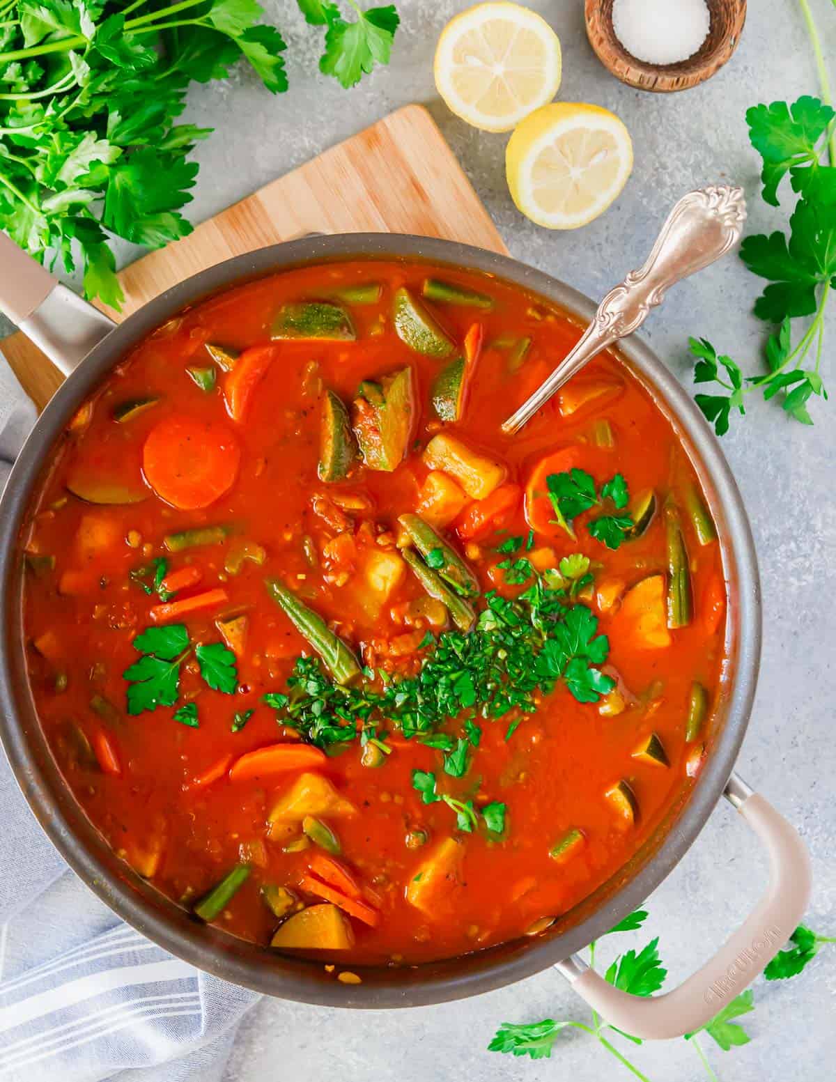 Pot of mung bean soup with vegetables, crushed tomatoes and lemon.