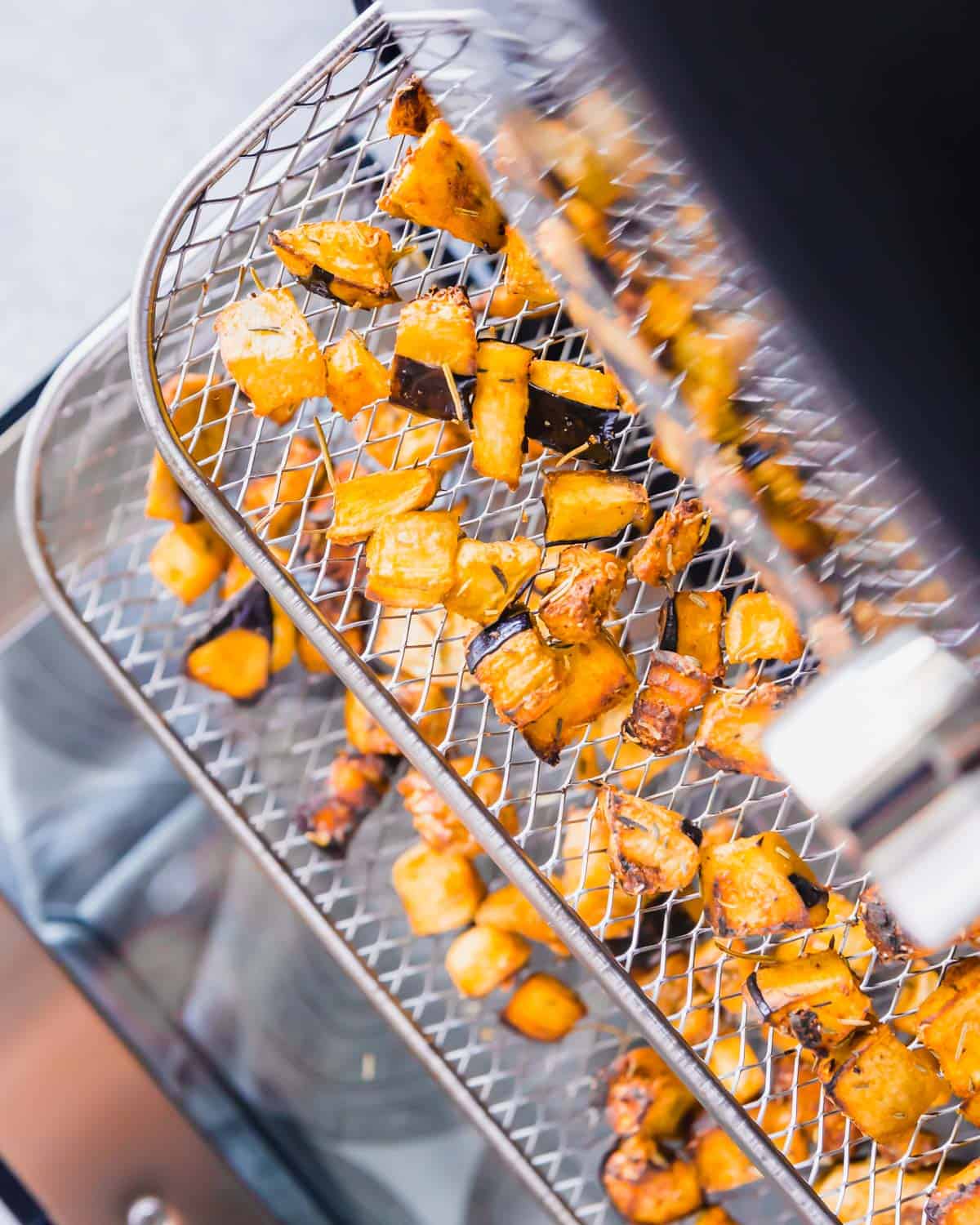 Eggplant cubes on a tray in the air fryer after roasting.