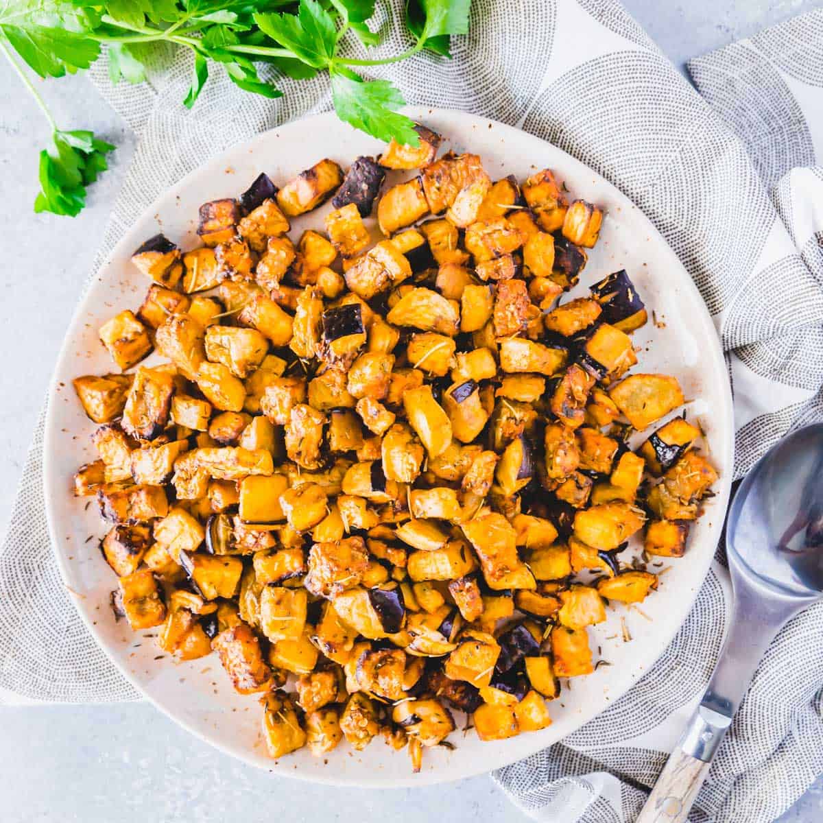 This simply seasoned air fryer eggplant comes out crispy and delicious. It's an easy side dish everyone will absolutely love and goes with almost any main course. Crispy air fryer eggplant recipe plated with fresh parsley.