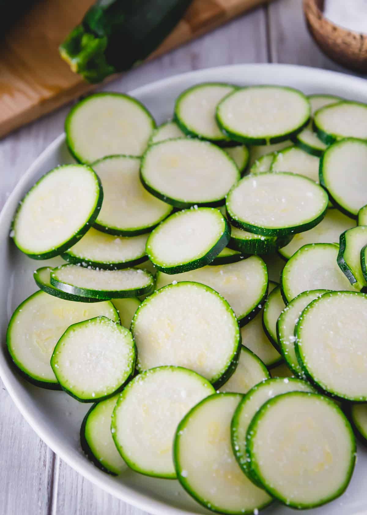 Salted zucchini slices to make air fried zucchini chips.
