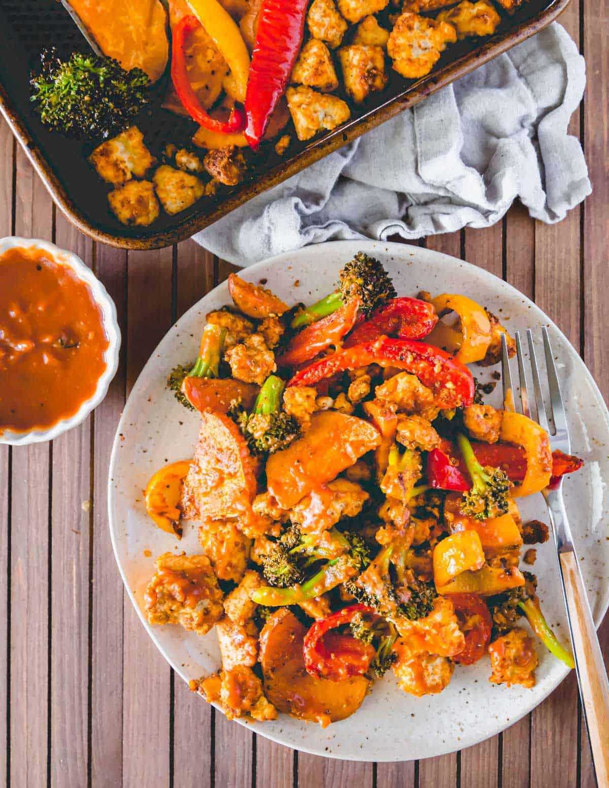 BBQ tofu, broccoli, peppers and sweet potatoes made on a baking sheet in the oven.