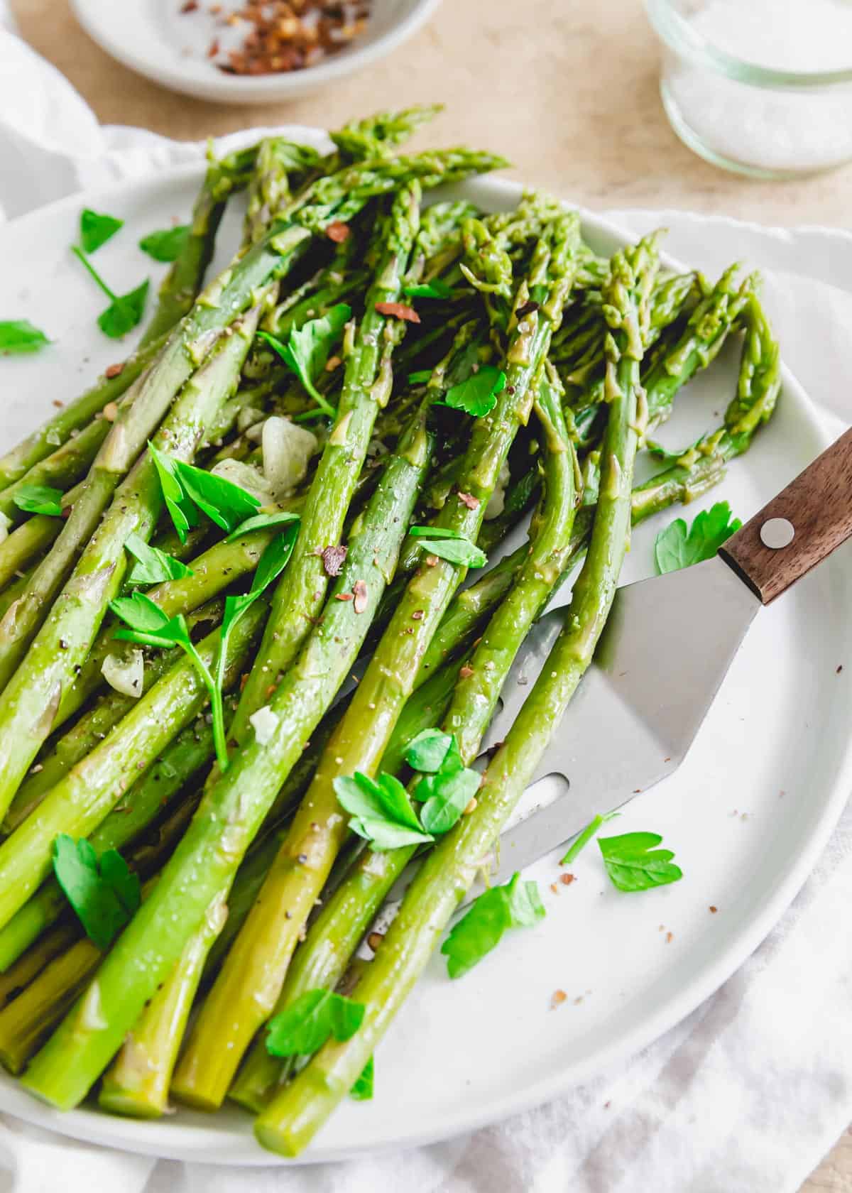 Asparagus cooked in the Instant Pot in just minutes on a plate with a serving spatula.