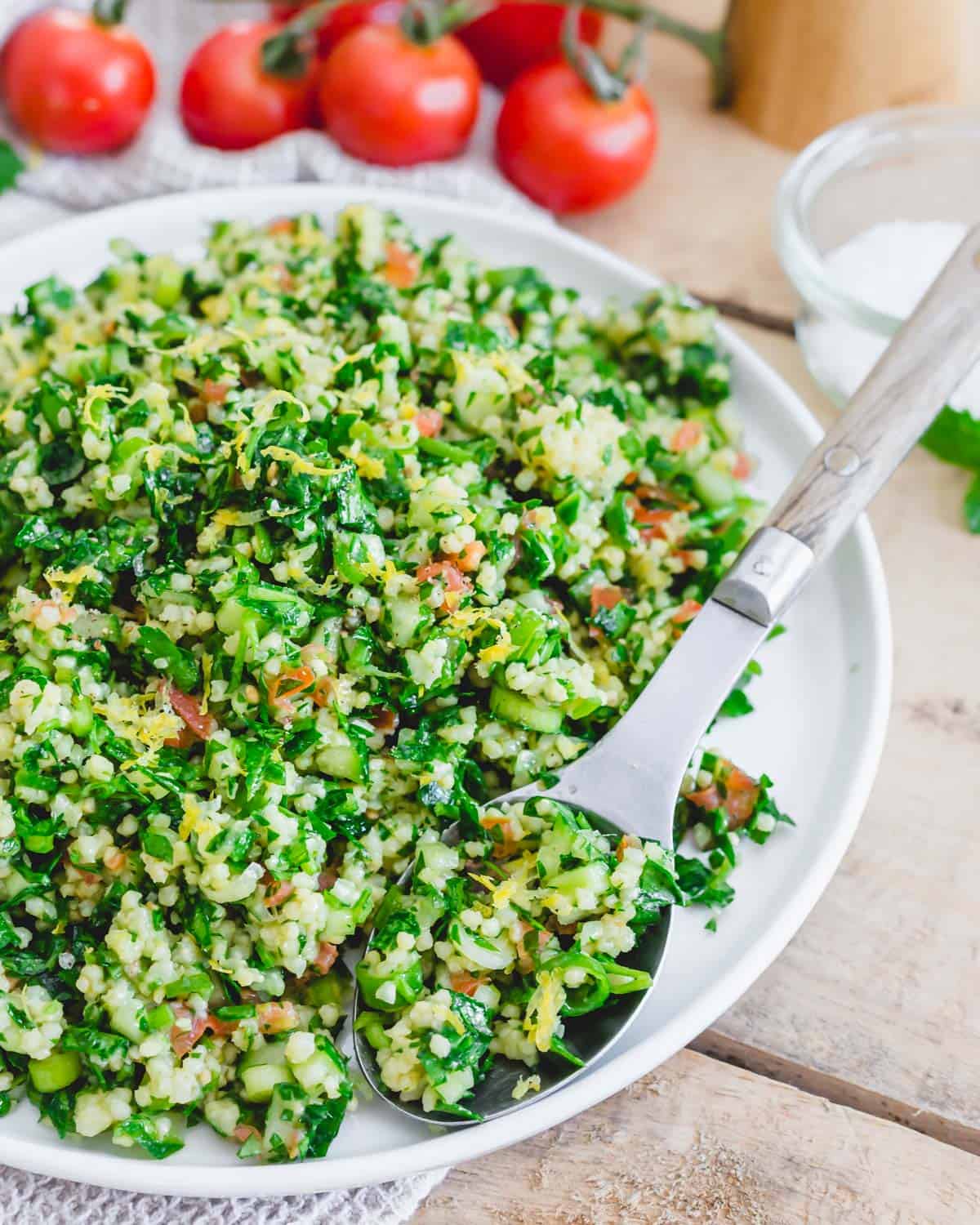 Gluten-free organic tabbouleh recipe made with millet on a plate with a serving spoon.