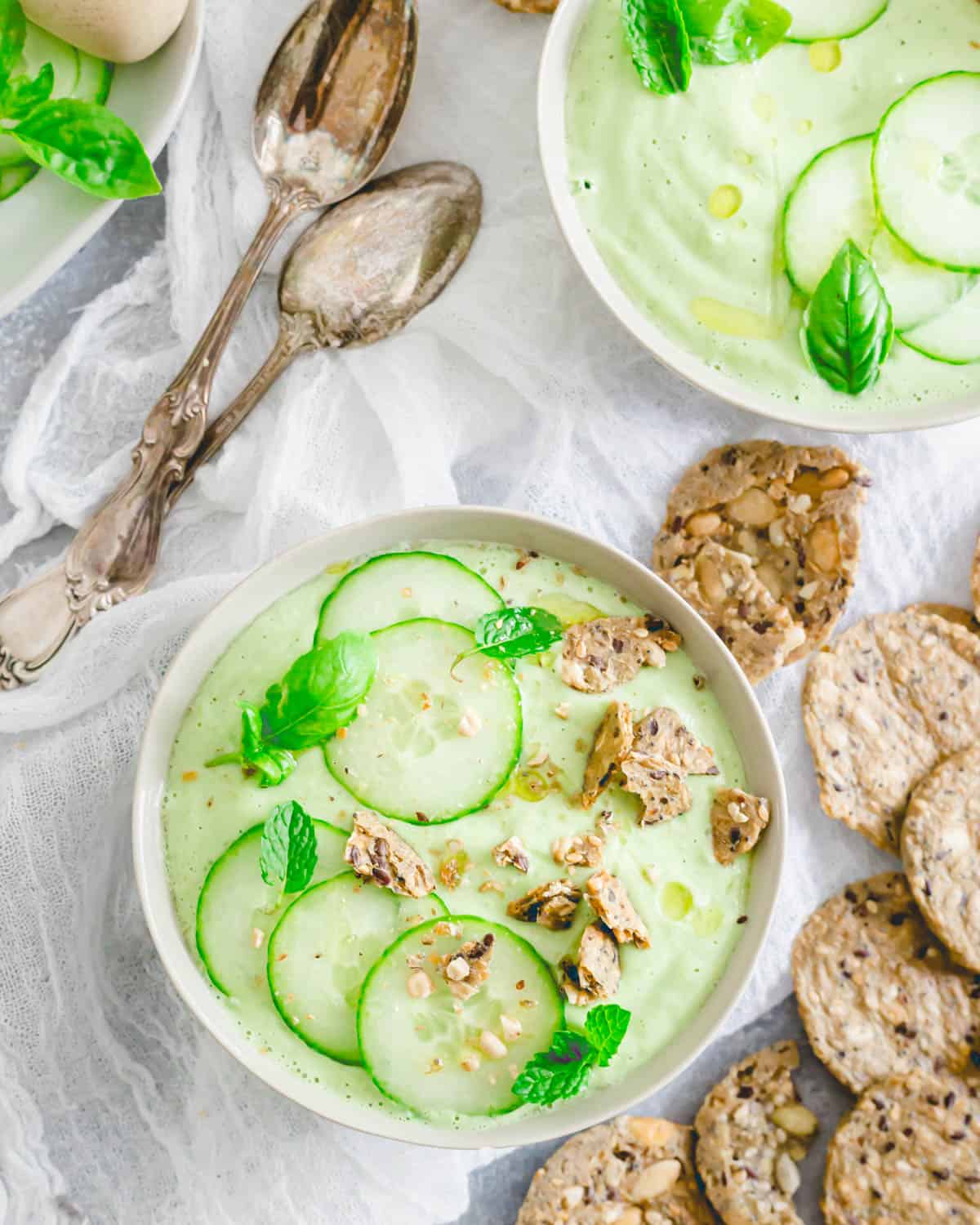 Crunchy crackers crumbled on top of cucumber gazpacho in small bowls.