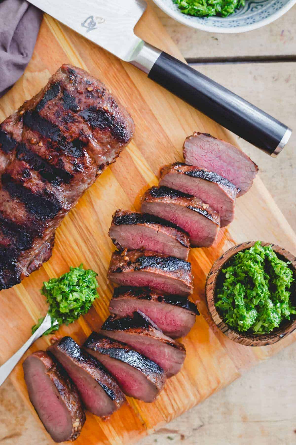 Perfectly grilled venison backstrap sliced and served with a ramp pesto.