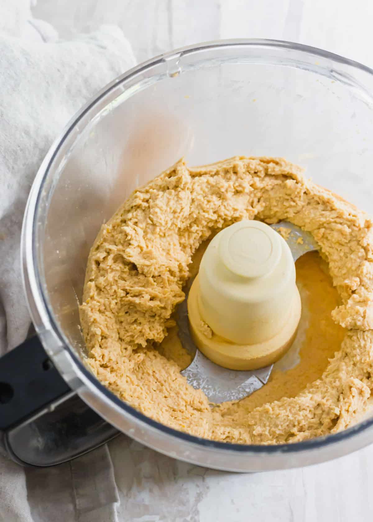 Chickpea blondie batter in a food processor before adding chocolate chips.