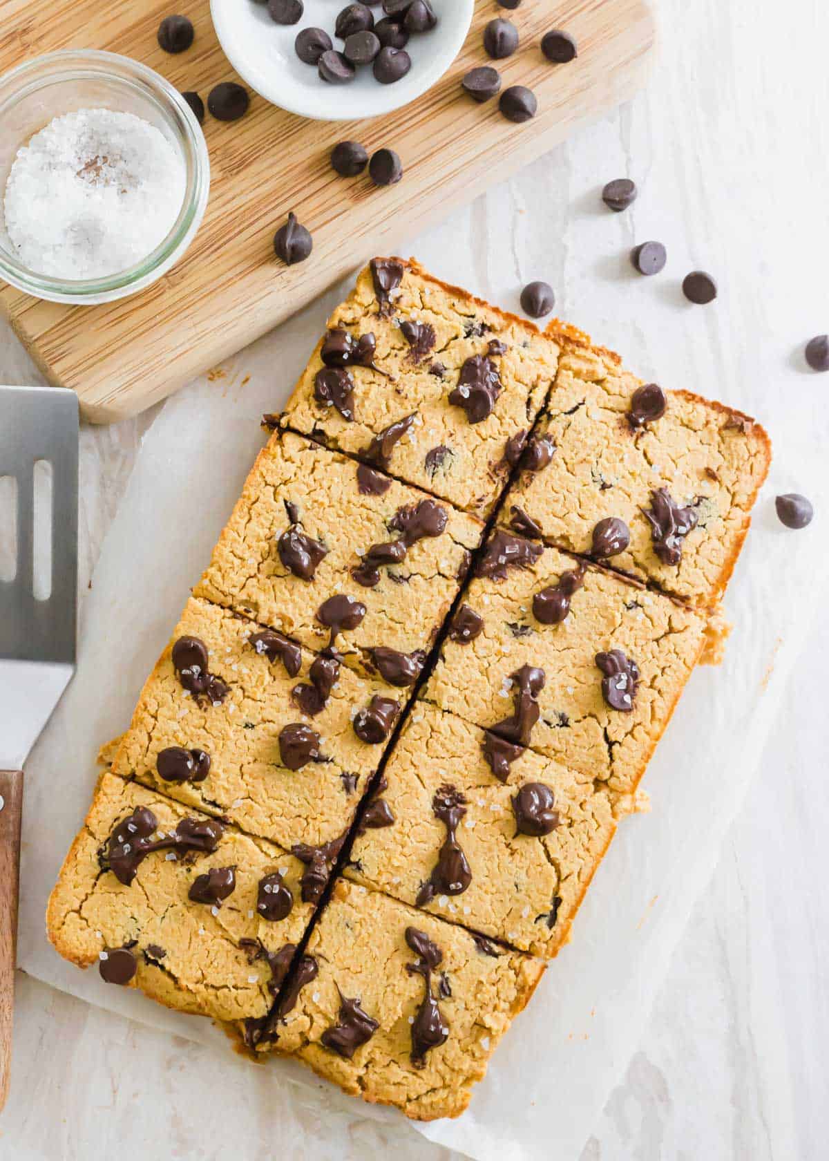 Baked chickpea blondies cut into 8 bars and sprinkled with flaky sea salt.