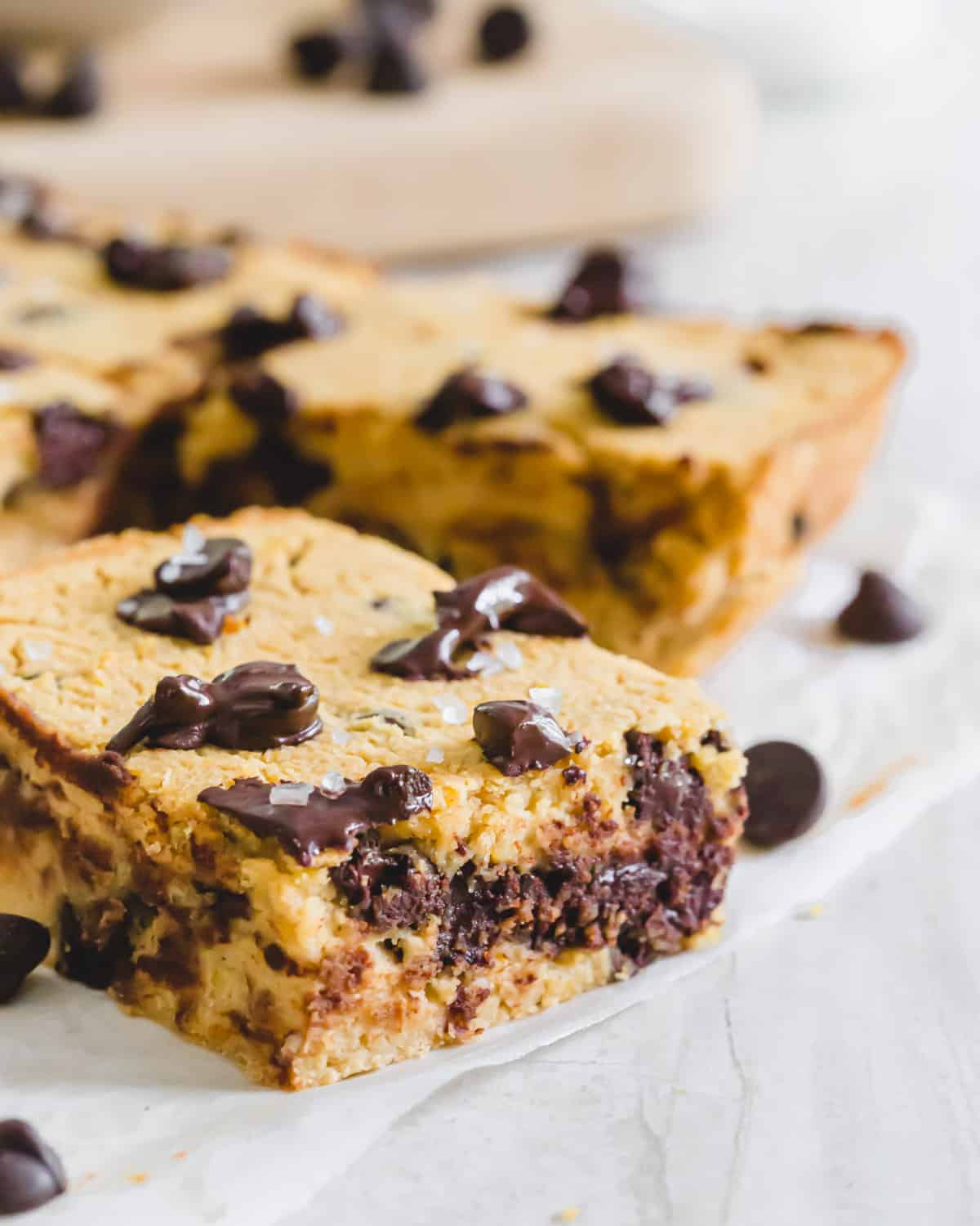Decadent vegan and gluten-free chickpea blondies cut into bars on parchment paper.