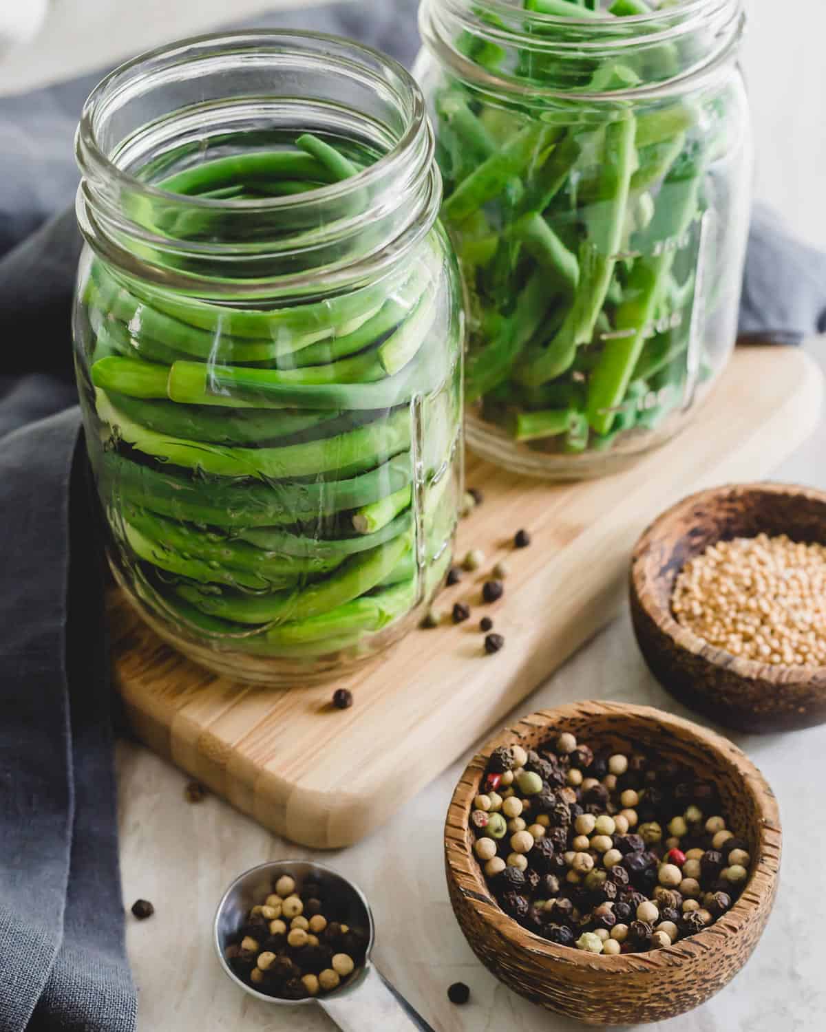 Garlic scapes in mason jars before pickling.