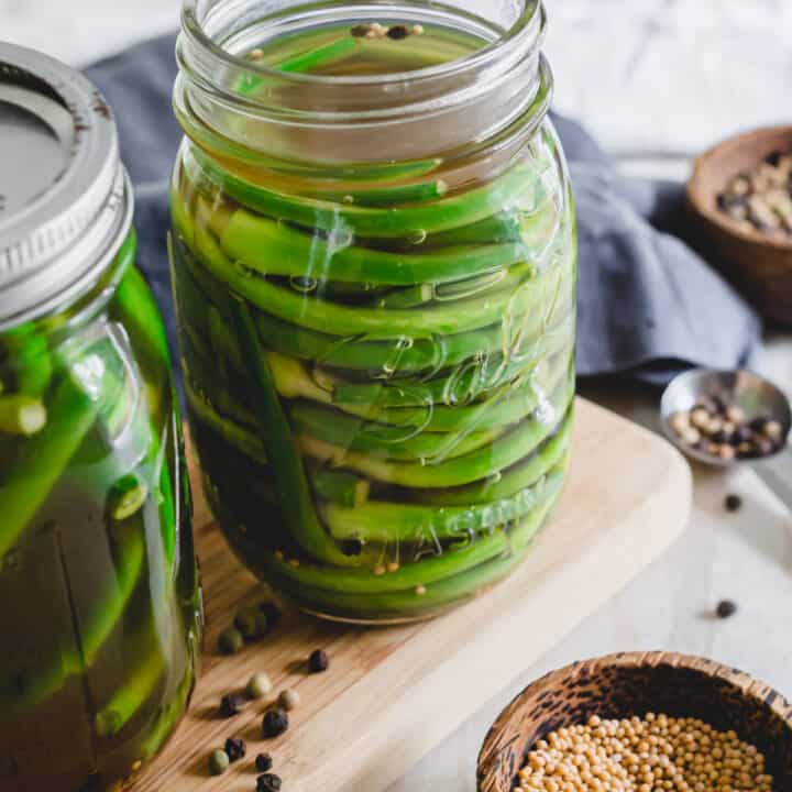 Pickled garlic scapes in a mason jar.