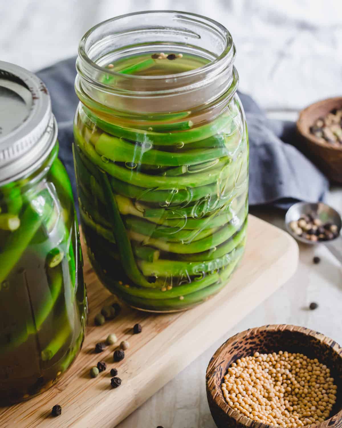 Pickled garlic scapes in a mason jar.