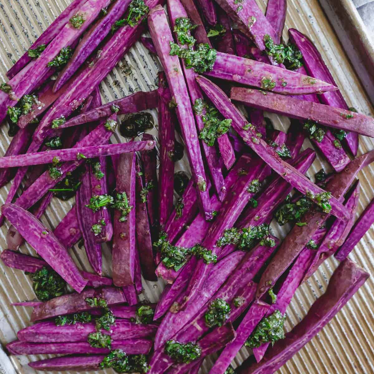 Stokes purple sweet potatoes cut into "fries" with herbs and oil before baking.