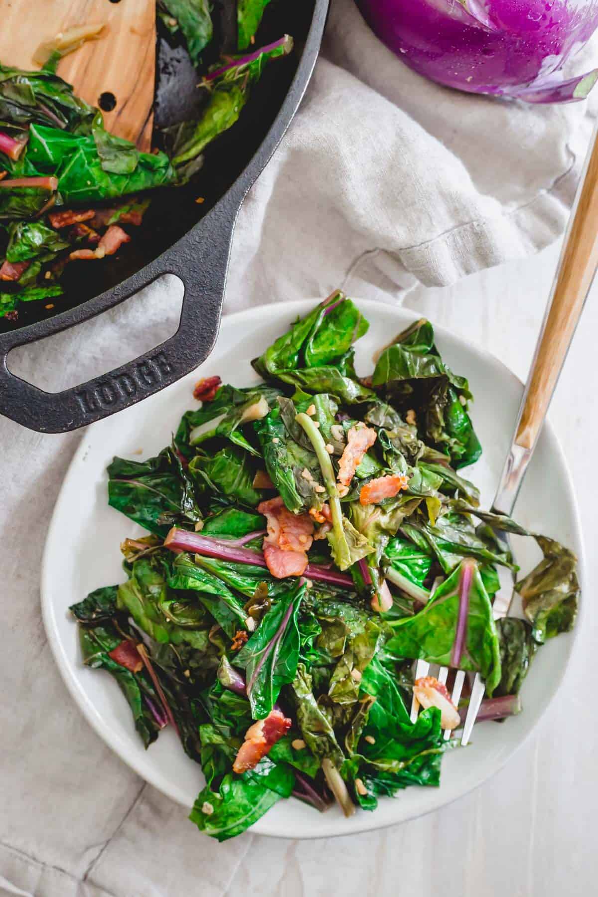 Cooked kohlrabi greens side dish with bacon, scallions and garlic.