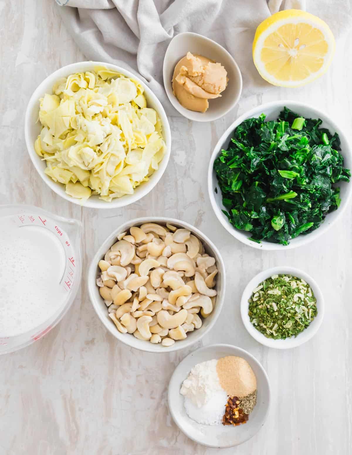 Plant based ingredients to make baked vegan spinach artichoke dip.