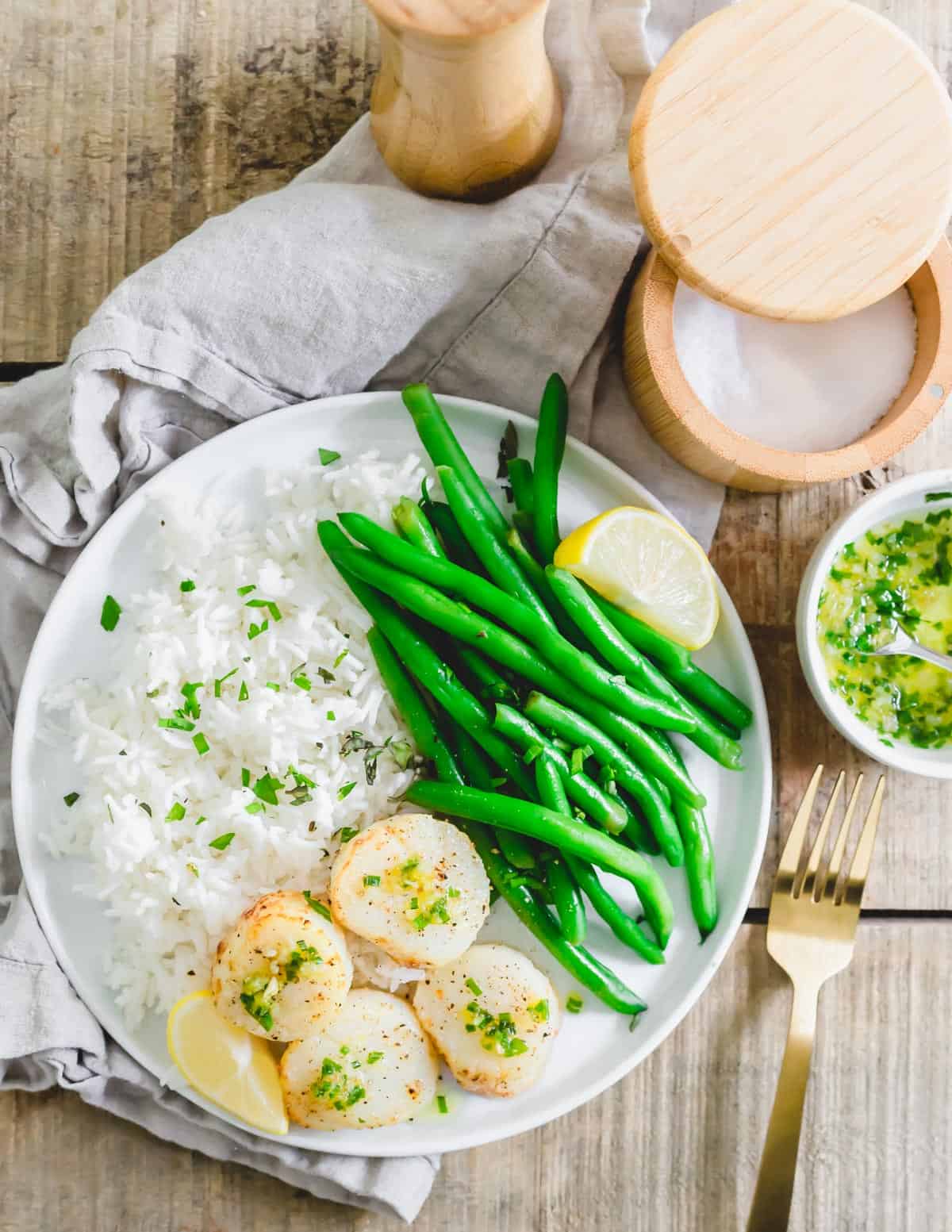 Air fryer sea scallops served with a butter chive garlic and lemon sauce, rice and green beans.