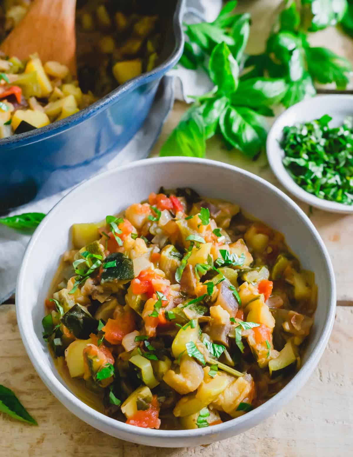 Ciambotta, Italian vegetable stew in a bowl with fresh basil.