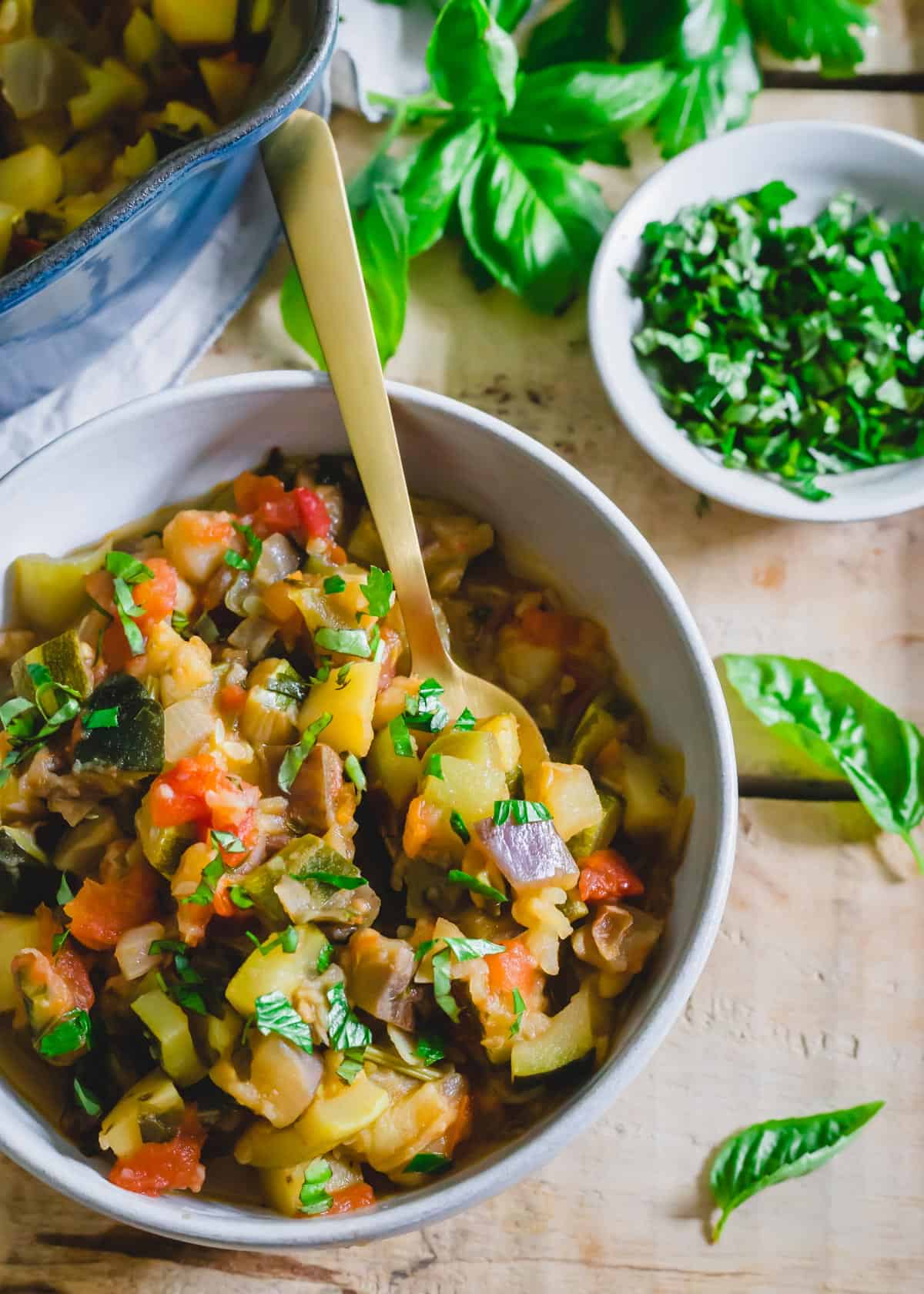 Ciambotta in a bowl with a serving spoon.