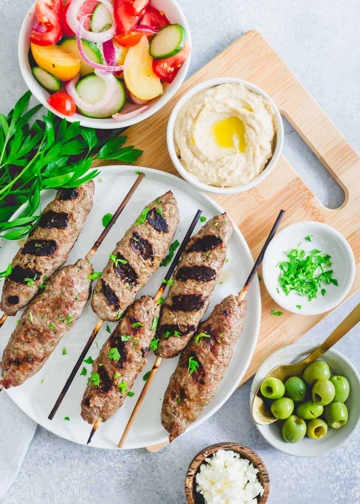 Grilled beef kafta kabobs on a plate with parsley.