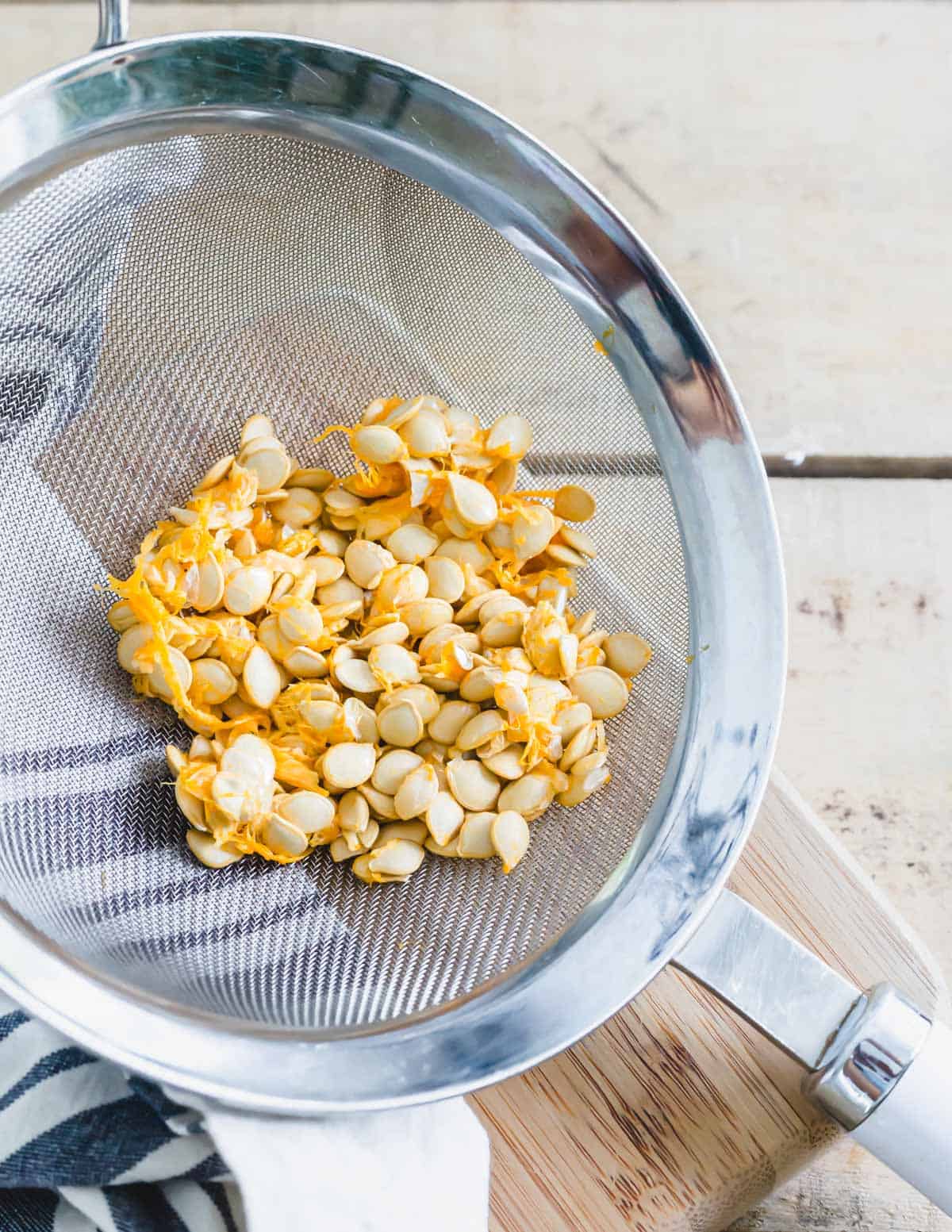 Delicata squash seeds in a strainer.