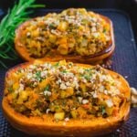 Stuffed honeynut squash on a baking sheet.
