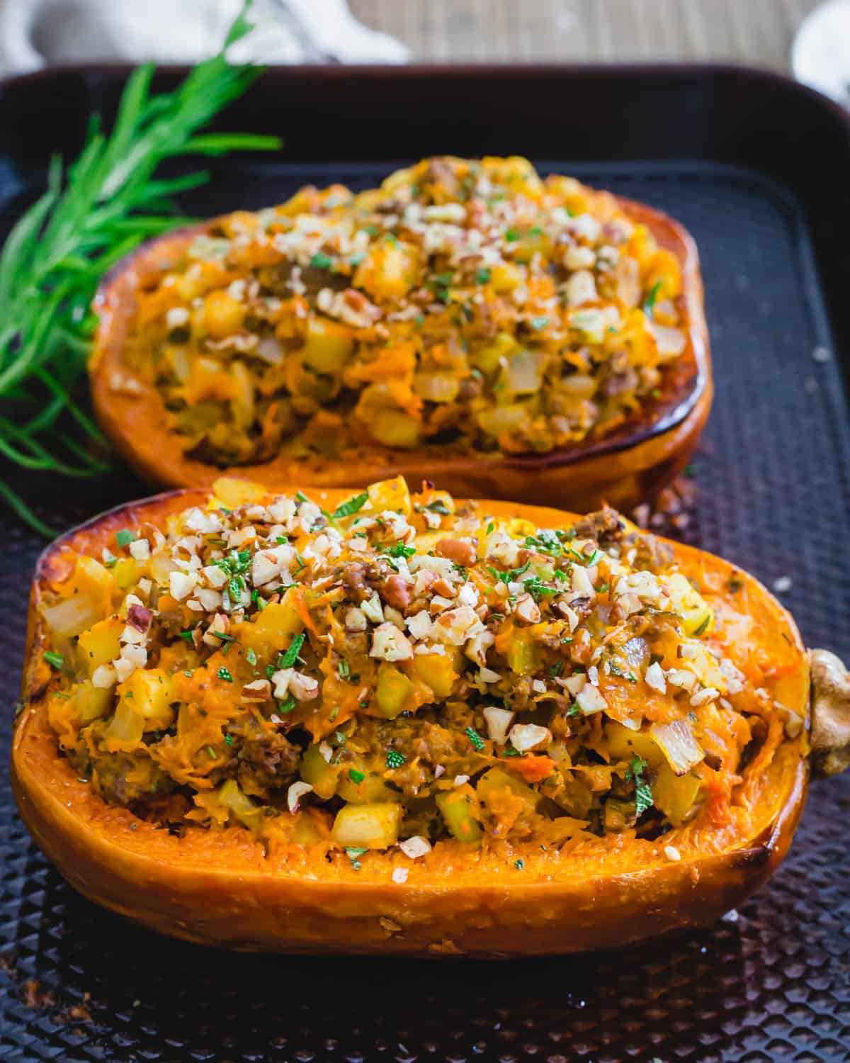 Stuffed honeynut squash on a baking sheet.