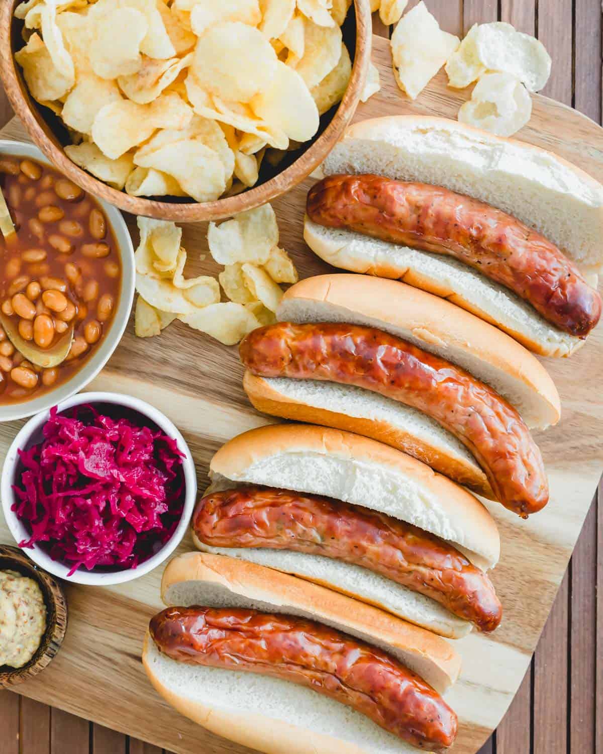 Perfectly cooked juicy bratwurst in the air fryer served with buns, potato chips, baked beans and sauerkraut.