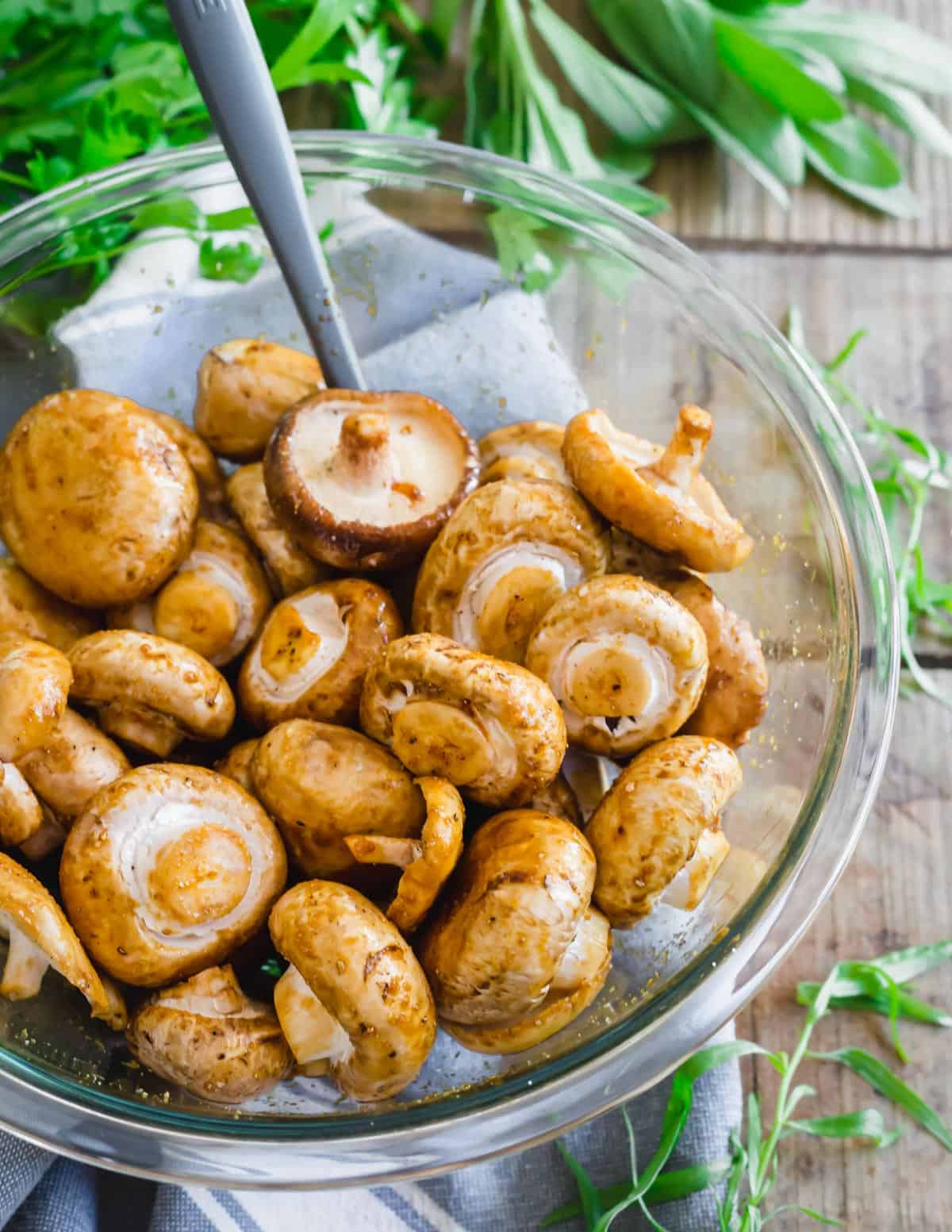 Seasoning mushrooms to be cooked in the air fryer with garlic, tamari and worcestershire sauce.