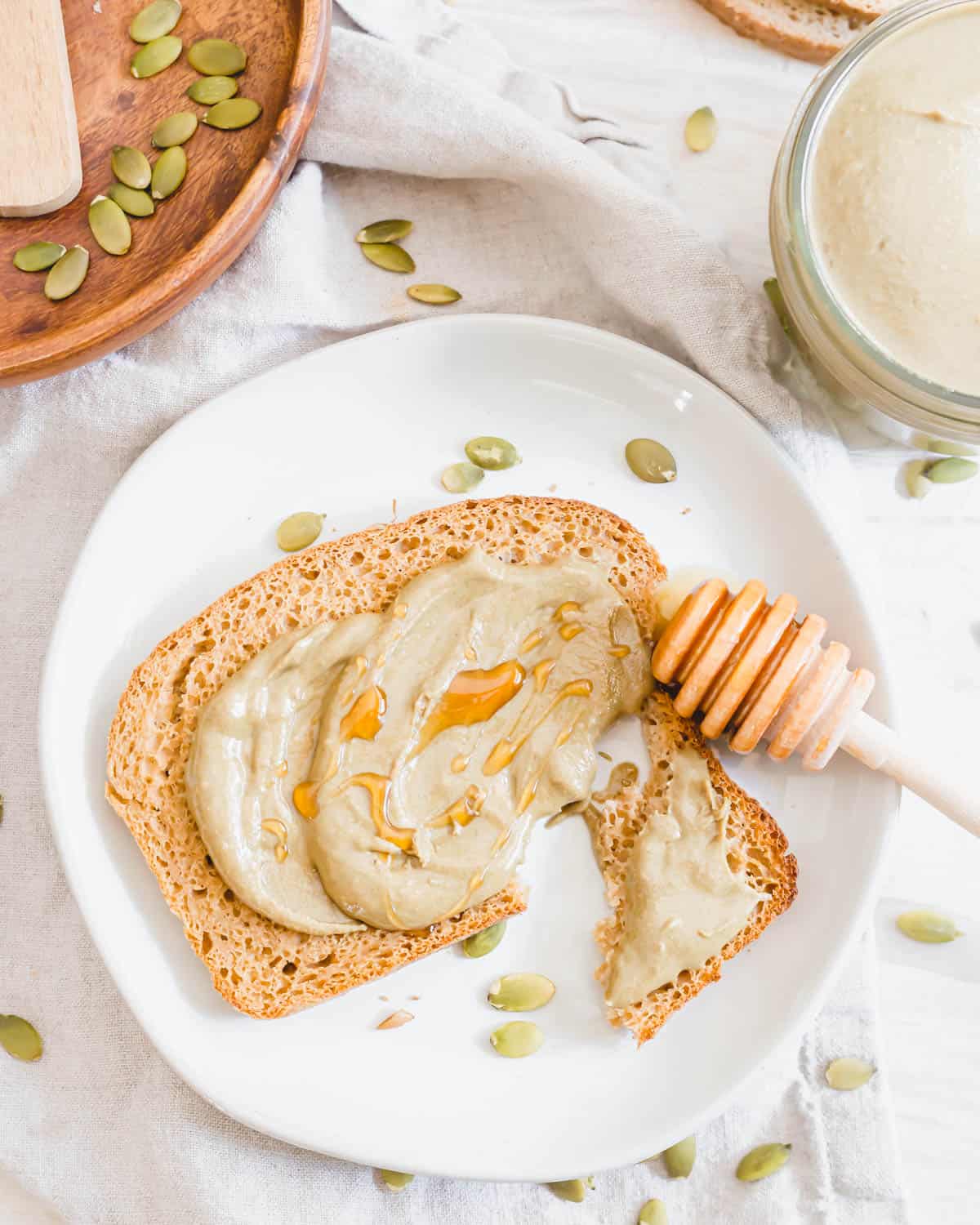 Nut-free pumpkin seed butter spread on toast with raw honey drizzled on top.