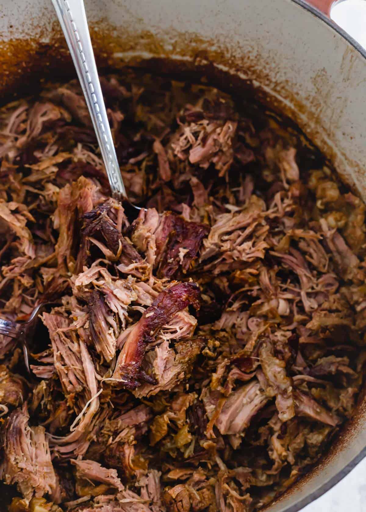 Tender, juicy and shredded braised leg of lamb in a Dutch oven.