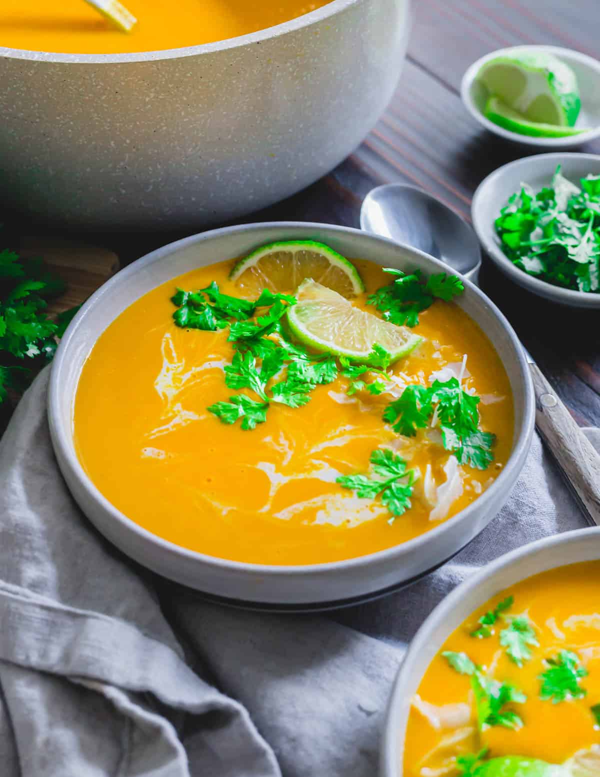 Buttercup squash soup garnished with cilantro, lime and coconut.