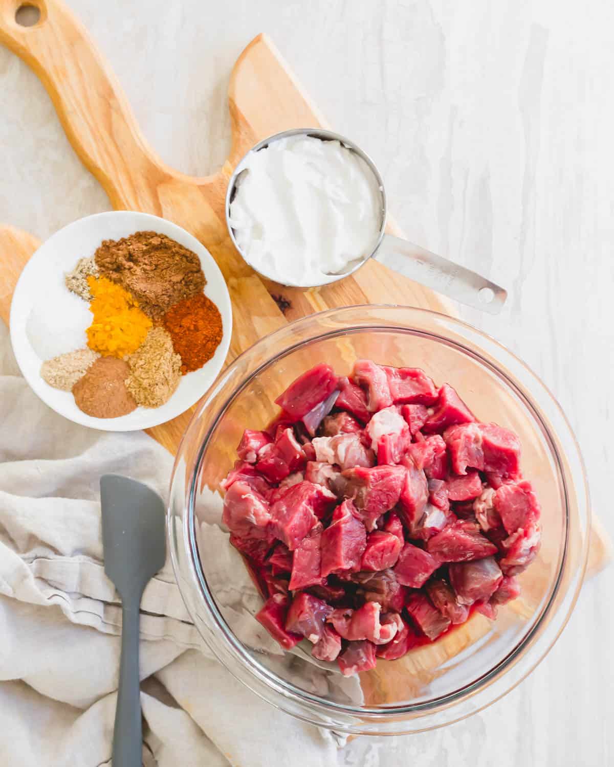 Ingredients to make dairy free lamb korma including boneless leg of lamb cut into pieces, aromatic spices and coconut yogurt.